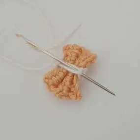 Threading the white ends through the middle loops of the bow tie