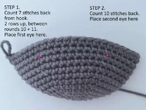 Crochet bat head with two pink dots marking where to place the safety eyes