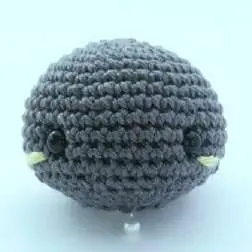 Gray crochet bat head with small lime blush stitches beside each eye