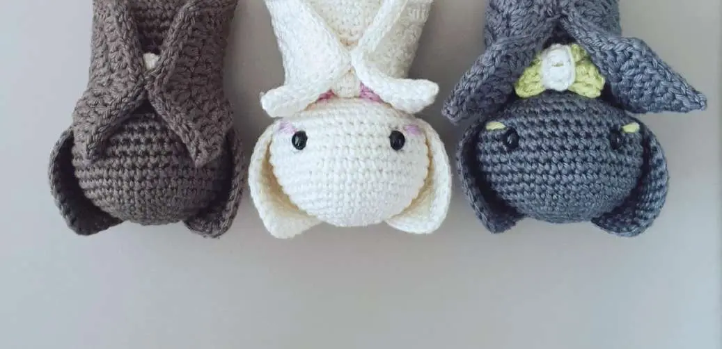 Three crochet baby bats in gray and white, finished and sitting together