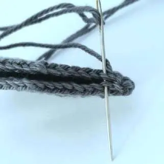 Needle stitching the folded wing edges together