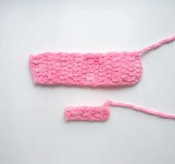 Two pink crochet strips, a long one for the bow and a short one for the band
