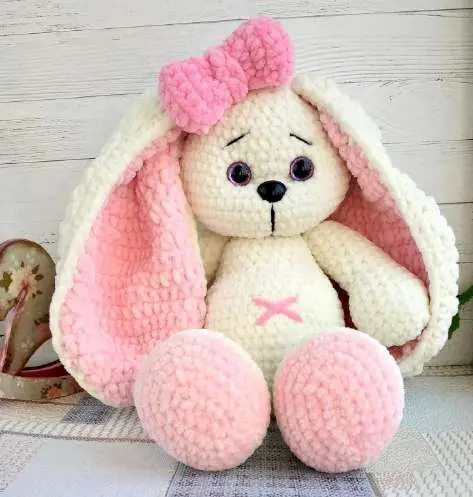 Cream crochet bunny with long pink-lined ears, a pink bow and pink feet