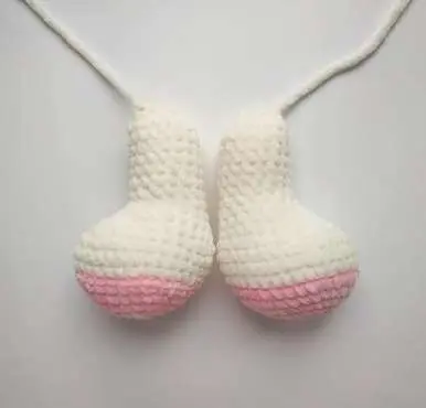 Two crochet bunny legs with pink soles, finished